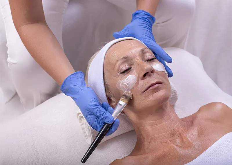 closeup-caucasian-senior-woman-applying-face-cream-beauty-salon